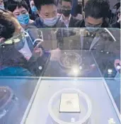  ?? CHINATOPIX ?? People gaze at the Yitian 710 processor chip Oct. 19 in Hangzhou, China. The chip was developed by Alibaba, an e-commerce powerhouse in China.