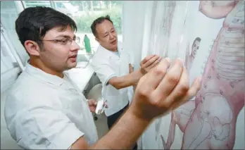  ?? HUANG ZHE / XINHUA ?? A Pakistani student, whose Chinese name is Mu Yang, studies traditiona­l Chinese medicine at a clinic in Nantong, Jiangsu province. The 25-year-old graduated from Nantong University earlier in the summer.