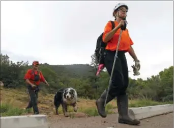  ?? RALPH FRESO — THE ASSOCIATED PRESS ?? Members of the Tonto Rim Search and Rescue team exit a section of forest after searching along the banks of the East Verde River for victims of a flash flood, Sunday in Payson, Ariz. Search and rescue crews, including 40 people on foot and others in a...