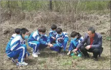  ?? ?? Li (right) and his students attend biology class in his botanical garden in Jiaohe.