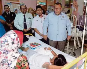  ?? BERNAMA PIC ?? Johor Education, Health and Human Resources Committee chairman Aminolhuda Hassan (right) visiting Influenza A patients at Sultanah Aminah Hospital in Johor Baru yesterday.