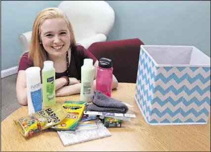  ?? HENRY TAYLOR / HENRY.TAYLOR@AJC.COM ?? Kristina Welch, 19, has collected an assortment of items for a care package that’s part of a service project she started called The Julia Project. She puts together the packages for teenagers living in halfway homes as they recover from addiction.