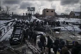  ?? FELIPE DANA — THE ASSOCIATED PRESS FILE ?? Ukrainians cross an improvised path under a destroyed bridge while fleeing Irpin in the outskirts of Kyiv, Ukraine, on March 8, 2022.