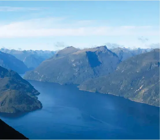  ??  ?? Tweedy Club on Secretary Island Doubtful Sound: Stunning views of the fjords can be obtained from above bushline. Pictured here is a member of the ‘Tweedy Club’, four paddlers who I met in Doubtful Sound, looking east towards the Fiordland mountains....