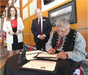  ?? CITIZEN FILE PHOTO ?? Tracy Calogheros and David Bird of The Exploratio­n Place watch as Chief Dominick Frederick of the Lheidli T’enneh signs a Memorandum of Understand­ing between the Lheidli T’enneh Nation and the Fraser Fort George Museum Society prior to the opening the...