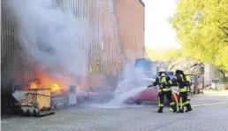  ?? BILD: JENS SCHOPP ?? Löscharbei­ten: Auch außerhalb der Halle brannte es. Wehrleute versuchten auch, das Auto zu schützen.