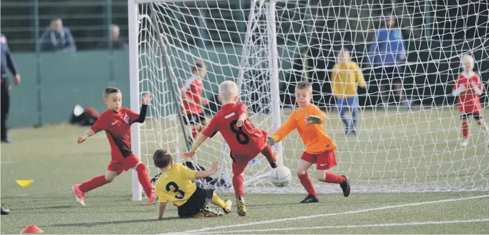  ??  ?? Action from the Russell Foster Under-7s League fixture between Washington AFC Blacks (red) and Hebburn Town Blues Barca, which was played at Temple Park Centre, South Shields.