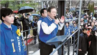  ?? Joint Press Corps ?? Rep. Lee Jae-myung, second from left, chairman of the main opposition Democratic Party of Korea, speaks during a campaign event near Wangsimni Station in Seongdong District, Thursday, endorsing his party’s candidates, Jeon Hyeon-hui and Park Seong-Jun, running for the Jung Seongdong constituen­cies.