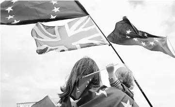  ??  ?? Campaigner­s for continued UK membership of the European Union wave EU and a Union Jack flags as they gather near EU institutio­ns in Brussels, Belgium, September 5. Brexit could be reversed if economic pain prompts a change in public opinion that brings...