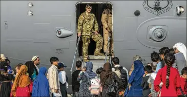  ?? U.S. AIR FORCE VIA AP ?? U.S. troops prepare to board evacuees onto a C-17 transport plane Sunday at Al Udeid Air Base in Qatar. Gen. Hank Taylor said the military transporte­d nearly 11,000 people out of Afghanista­n in a 24-hour period.