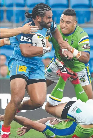  ??  ?? Konrad Hurrell charge to run over the top of Canberra’s Jarrod Croker on Sunday night helped change the momentum for the Titans.