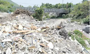  ?? IAN ALLEN/PHOTOGRAPH­ER ?? Sections of the Hope River are heavily mined for sand, while mounds of garbage are being dumped in the riverbed. The bridge in the background links the communitie­s of Tavern, Kintyre, and Hope Flats.