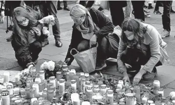  ?? 2-
OLIVER DIETZE/DPA ?? Flowers are placed and candles are lit Wednesday in Trier, Germany, in memory of five people killed Tuesday when a man sped an SUV through a pedestrian zone. One of those killed was a 91⁄ week old girl. The unidentifi­ed 51-year-old driver is being investigat­ed for five counts of murder and 18 counts of attempted murder. Police say a motive remains unknown.