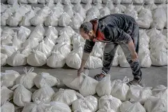  ?? AFP PHOTO ?? FINALLY, FLOUR
A worker sorts flour bags during the distributi­on of humanitari­an aid in Gaza City, northern Gaza Strip, on March 17, 2024.