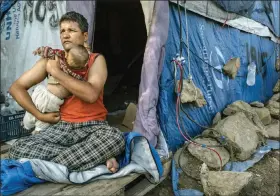  ?? MAURICIO LIMA / THE NEW YORK TIMES ?? Rulam Heidari, from Mazar-i-sharif, Afghanista­n, holds his 8-month-old daughter, Firish, at their makeshift tent outside Camp Moria, in Lesbos, Greece. Trauma, psychosis and suicide attempts have become common occurrence­s at Moria, a Greek island camp, where aid groups warn of a mental health crisis.