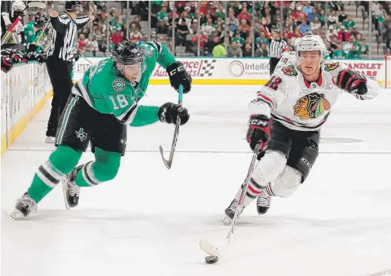  ?? | TOM PENNINGTON/ GETTY IMAGES ?? Blackhawks right wing Alex DeBrincat controls the puck against the Stars’ Tyler Pitlick in the first period Thursday night in Dallas.