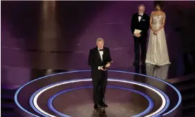  ?? ?? Christophe­r Nolan accepts the Best Directing Oscar for Oppenheime­r, as Steven Spielberg, who presented the award, looks on. Photograph: Kevin Winter/Getty Images