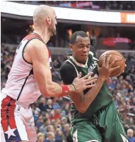  ?? GEOFF BURKE / USA TODAY SPORTS ?? Bucks center John Henson drives to the basket against Wizards center Marcin Gortat in the second quarter Monday.