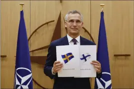  ?? JOHANNA GERON V ?? NATO Secretary-General Jens Stoltenber­g displays documents as Sweden and Finland applied for membership in Brussels, Belgium, on Wednesday.