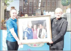  ?? (Photo: Katie Glavin) ?? Ciara Noonan and William Hughes pictured with a photo taken at the Rochestown Park Hotel in 2014 of Mr Hughes with Katie Taylor and her father and former amateur coach, Pete Taylor.