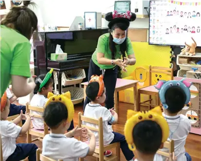  ??  ?? Teachers show children how to wash their hands at Wanlicheng Experiment­al Kindergart­en as local public kindergart­ens reopened yesterday. — All photos by Jiang Xiaowei