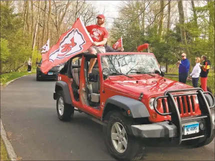  ?? Scott Ericson / Hearst Connecticu­t Media ?? Friends drive by Lucas Niang’s house on April 25 waving a Kansas City Chiefs flag, after the New Canaan alum was drafted by the NFL team the day before. Below, A caravan of players, former teammates and friends parade past the homes of Stamford High School’s Class of 2020 senior softball players Emily Ferretti and Morgan Yacavone.