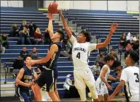  ?? AUSTIN HERTZOG - DIGITAL FIRST MEDIA ?? Upper Merion’s Matthew Choi scores on a layup as Pottstown’s Tre Bass (4) defends.