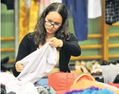  ??  ?? Good buy . . . Carrington College resident Alex Hewitt (17) hunts for a bargain at the University of Otago O Week Drop for Good sale at Smithells Gymnasium yesterday.