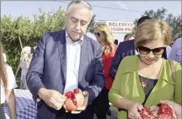  ??  ?? President Mustafa Akıncı (centre) and ‘first lady’ Meral Akıncı enjoy the offerings of pomegranat­e