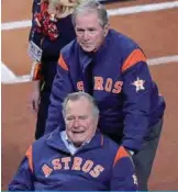  ?? —AFP ?? HOUSTON: Former United States Presidents George W Bush and George H W Bush look on after throwing out the ceremonial first pitch before game five of the 2017 World Series between the Houston Astros and the Los Angeles Dodgers.