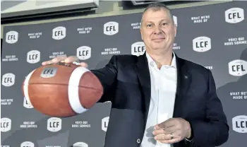  ?? FRANK GUNN/THE CANADIAN PRESS ?? Randy Ambrosie holds a football Wednesday in Toronto after being named the 14th commission­er in CFL history.