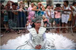  ??  ?? A member of a samba school waits for the start of a street parade at Copacabana beach in Rio de Janeiro, Brazil.