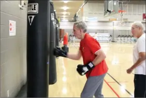  ?? The Sentinel-Record/Tanner Newton ?? PACKING A PUNCH: A Rock Steady Boxing fighter works a punching bag recently at First Baptist Church. The workout is designed to help people cope with the symptoms of Parkinson’s disease.