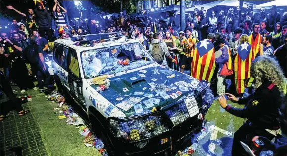  ?? EFE ?? Los radicales destrozaro­n los coches de la Guardia Civil durante las protestas ante la Consejería de Economía días antes del 1-O