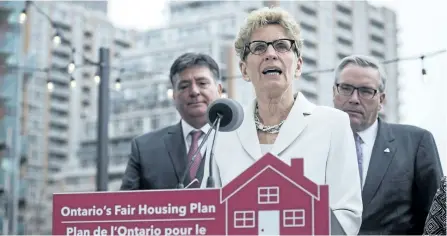  ?? CHRISTOPHE­R KATSAROV/THE CANADIAN PRESS ?? Ontario Premier Kathleen Wynne, centre, is joined by Finance Minister Charles Sousa, left, and Housing Minister Chris Ballard on Thursday in Toronto.