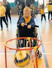  ??  ?? Slam dunk Thomas has fun trying out wheelchair basketball