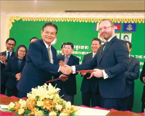  ?? HENG CHIVOAN ?? Secretary of State at the Ministry of Public Works and Transporta­tion Touch Chan Kosal (left) and Pi Pay CEO Tomas Pokorny shake hands to seal an agreement for the ministry to utilise the cashless payment gateway.