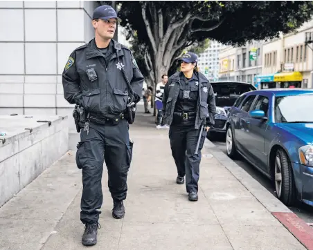  ?? Jessica Christian / The Chronicle ?? Police Officers Maher (left) and Richmond patrol Grove Street near the Civic Center Plaza area in S.F.’s gritty Tenderloin.