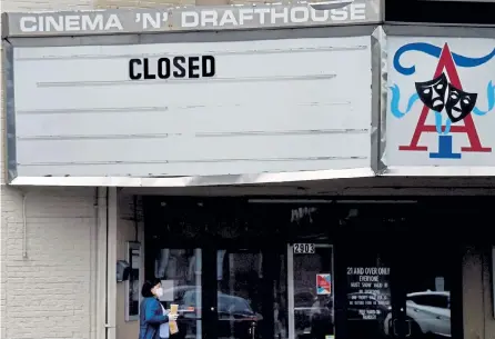  ?? Olivier Douliery, AFP via Getty Images ?? A woman walks past the closed Arlington Cinema and Drafthouse movie theater amid the coronaviru­s pandemic in Arlington, Va., in May. New filings for unemployme­nt benefits in the U. S. climbed to 742,000 last week, the Labor Department said on Thursday, reversing their recent decline amid a surge in COVID- 19 cases.