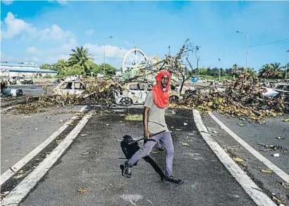  ?? RICARDO ARDUENGO / REUTERS ?? Barricada amb cotxes i arbres cremats a Guadeloupe