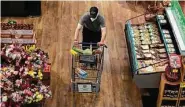  ?? Yi-Chin Lee / Staff photograph­er ?? Experts say shopping at a grocery store should be considered safe — as long as you wear a mask.