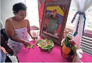  ??  ?? Petra Lezama prepares a salad with vegetables from her roof garden, where she keeps a photo of Venezuela’s late President Hugo Chavez in Caracas, Venezuela.
