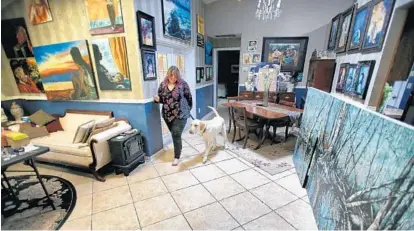  ?? JOE BURBANK/ORLANDO SENTINEL ?? Artist Libby Smith, who is legally blind, walks with her dog Django in her Orlando home.