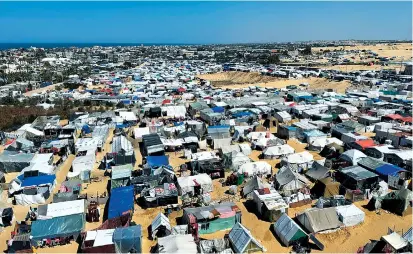  ?? Reuters-Yonhap ?? Displaced Palestinia­ns shelter in a camp in Rafah, Gaza Strip, in March.
