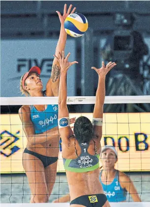  ?? SAM WASSON GETTY IMAGES ?? Heather Bansley of Canada attacks against Carolina Salgado Collet Solberg of Brazil during their semifinal match of the FIVB Las Vegas Open, which Bansley and Brandie Wilkerson, right, won.