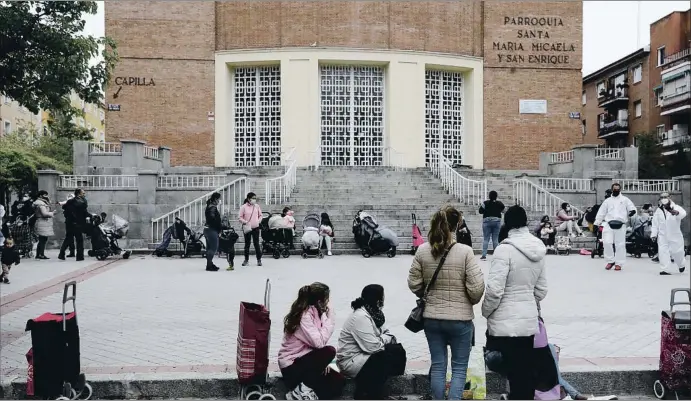  ?? EMILIA GUTIÉRREZ ?? Barrio de Tetuán No muy lejos del estadio del Real Madrid un grupo de hombres y mujeres, algunos con carros con niños, esperan en la cola de la comida