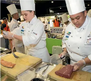  ?? PHOTO: SUPPLIED ?? Kate Bryant, left, takes on the salmon, while Keziah O’connor works alongside her on a cut of meat. The UCOL culinary students, competing in the Toque d’or competitio­n in Auckland on Friday.