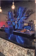  ?? TACO BAR ?? A tree-like metal sculpture holds bottles of tequila behind the bar at Taco Bar, 782 N. Jefferson St.
