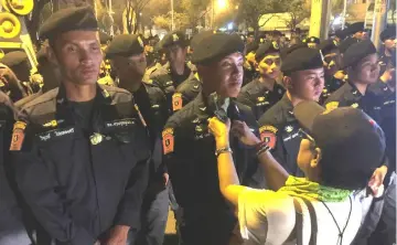  ?? — Reuters photo ?? In this file photo, a protester puts a rose on a riot police officer during a protest against junta, near the army headquarte­rs in Bangkok.