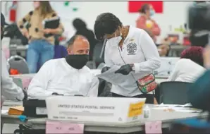  ?? (File PhotoAP/Carlos Osorio) ?? A worker checks with an election supervisor at the central counting board in Detroit. On Friday, The Associated Press reported on a video circulatin­g online incorrectl­y asserting it shows tens of thousands of illegal ballots delivered eight hours after the election night deadline at the TCF Center in Detroit. But it shows the city delivering legal ballots to be counted, as expected.